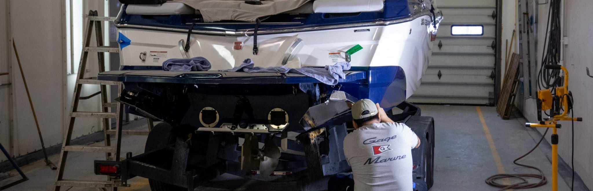 man working on boat in garage