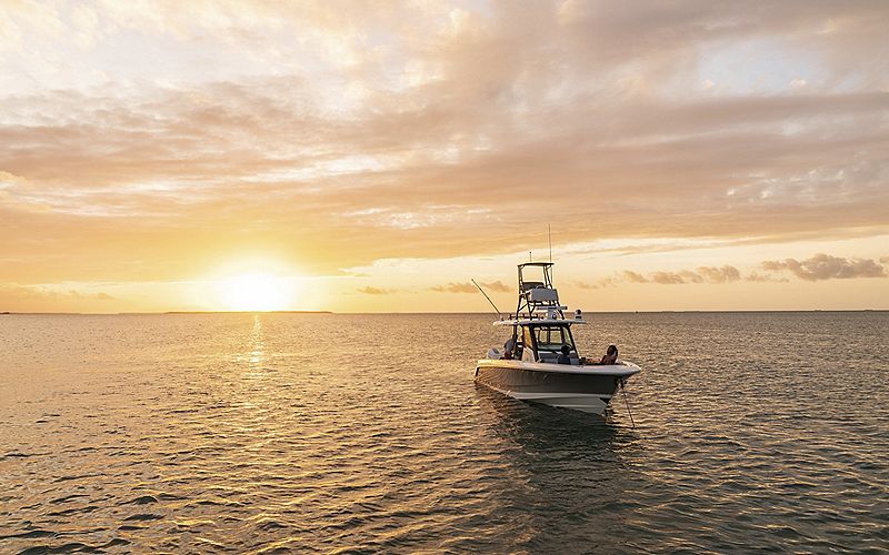 boat on water with sunset in background